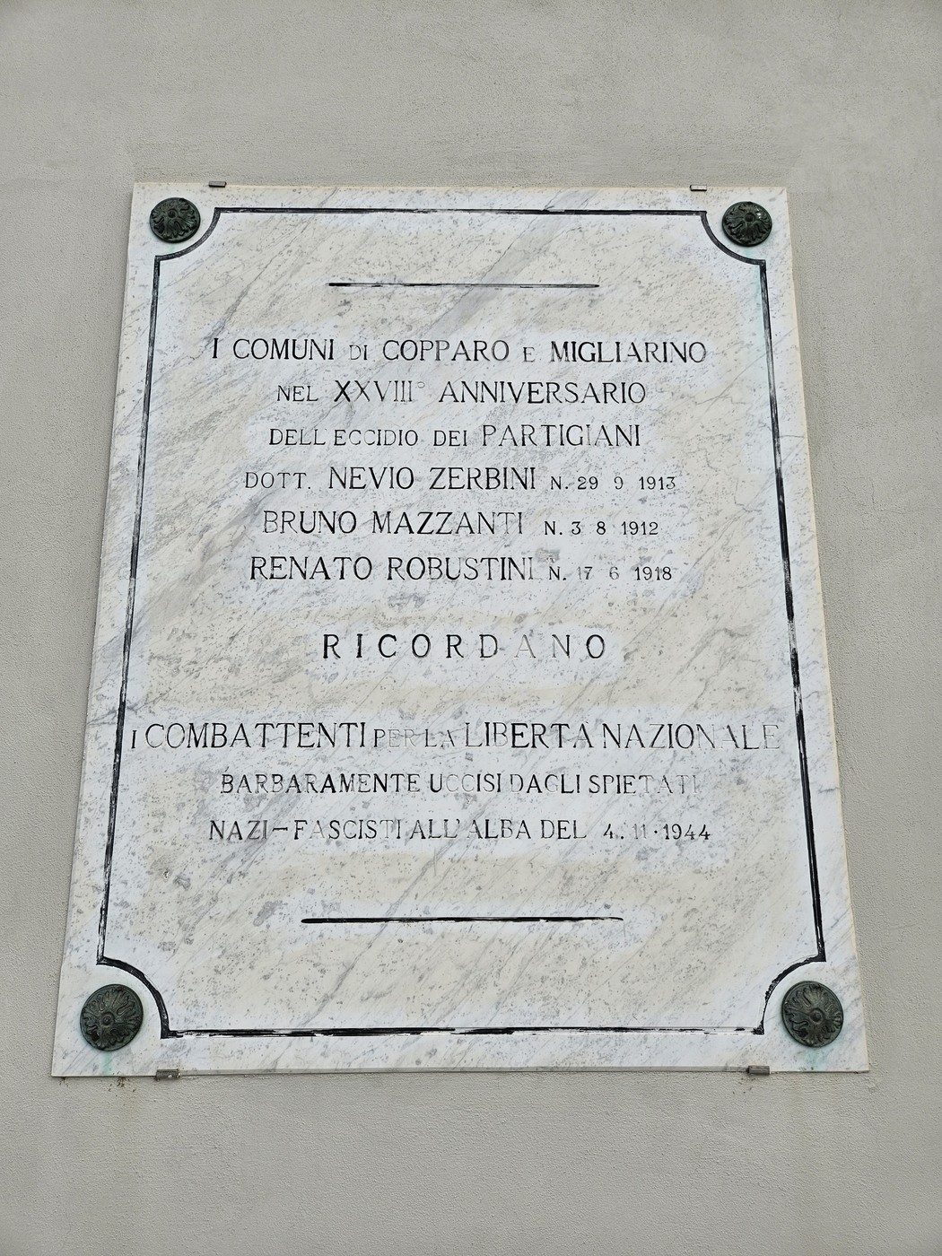 Lapide commemorativa in marmo dedicata ai partigiani Zerbini, Mazzanti e Donati, affissa su una parete.