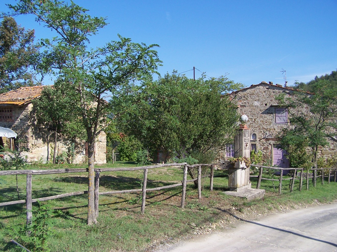 Immagine del Cippo di Santa Lucia, caratterizzato da case rustichette e un paesaggio naturale.