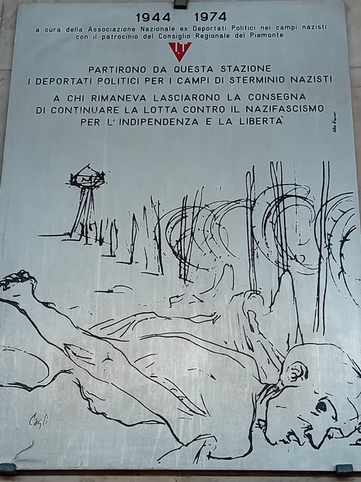 Lapide commemorativa dedicata ai deportati politici nei campi nazisti, con disegno evocativo sulla sofferenza umana.