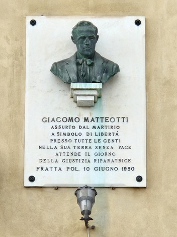 Lapide commemorativa di Giacomo Matteotti, simbolo di libertà e martirio, situata in una parete.