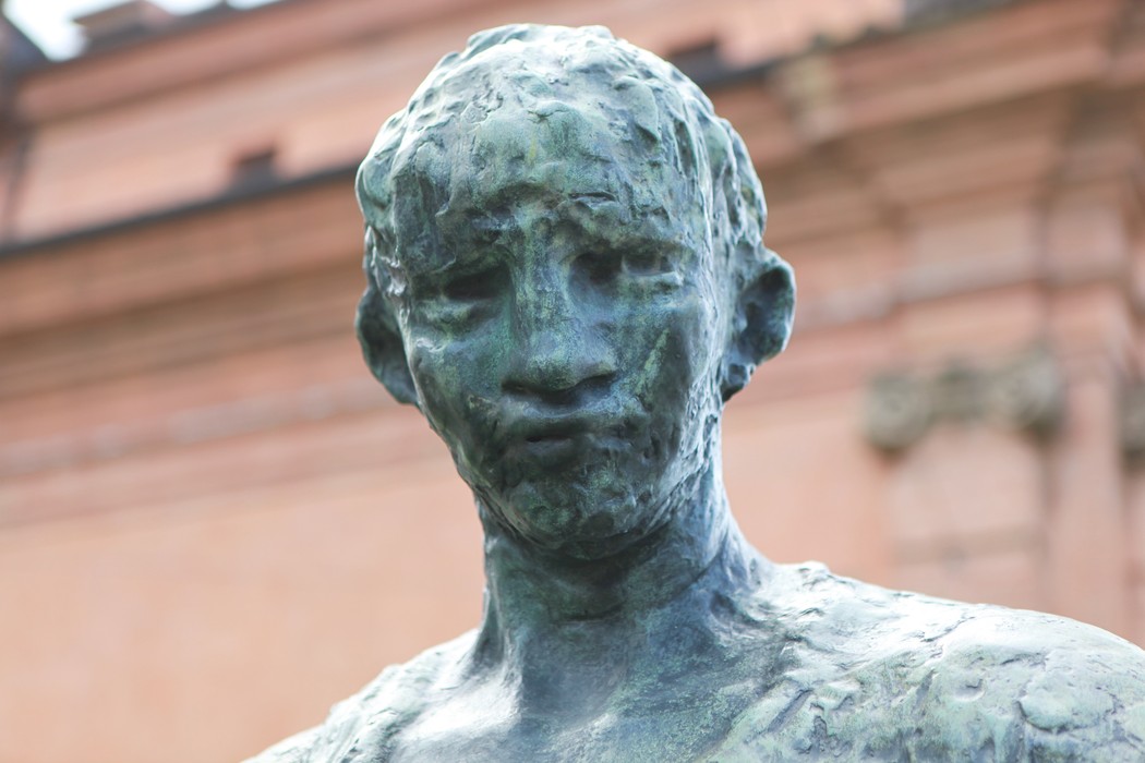 Scultura di un partigiano, rappresentante la lotta per la libertà e la resistenza. Dettagli realistici e espressione intensa.