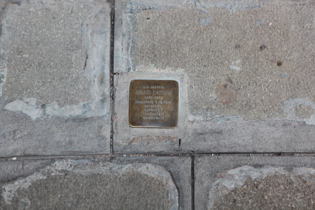 Pietra d'inciampo dedicata a Beniamino Bassani, incastonata nel pavimento urbano.