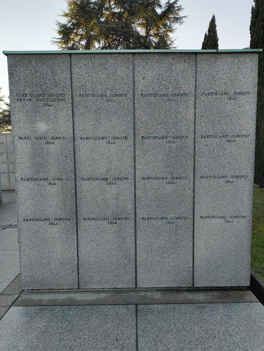 Monumento commemorativo al "Campo della Gloria", con nomi di caduti incisi su lastre di pietra.