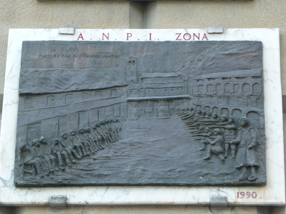 Targa commemorativa che onora i Tredici Martiri con rilievi che rappresentano momenti storici significativi.