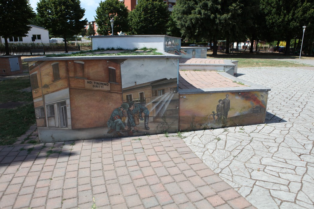 Murali colorati nel parco della Liberazione, rappresentanti scene storiche e comunitarie, tra natura e arte urbana.