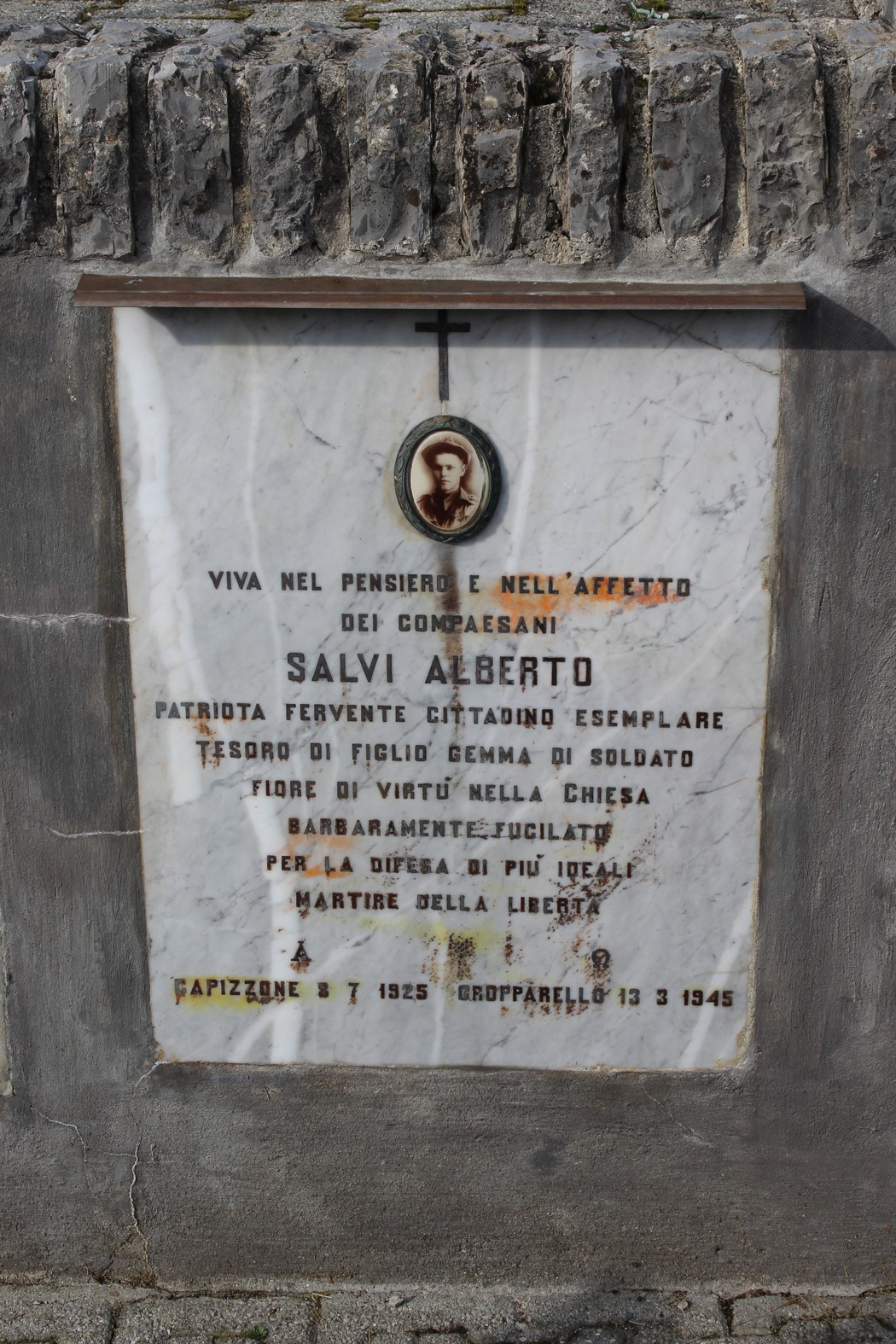 Lapide a Salvi, commemorativa di un patriota e martire della libertà, decorata con una croce e una foto.
