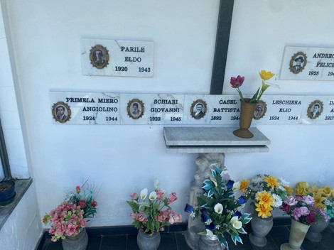 Interno della Cappella dei caduti per la libertà, con fiori e commemorazioni su pareti decorate.