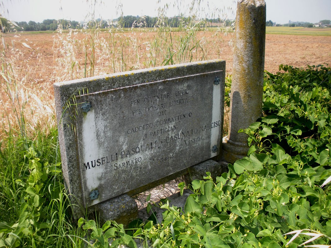 Cippo commemorativo a Casonato e Muselli, immerso in un paesaggio rurale.