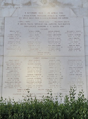 Lapide commemorativa dedicata ai caduti per la libertà, con nomi di martiri e combattenti. Ambiente solenne e riflessivo.