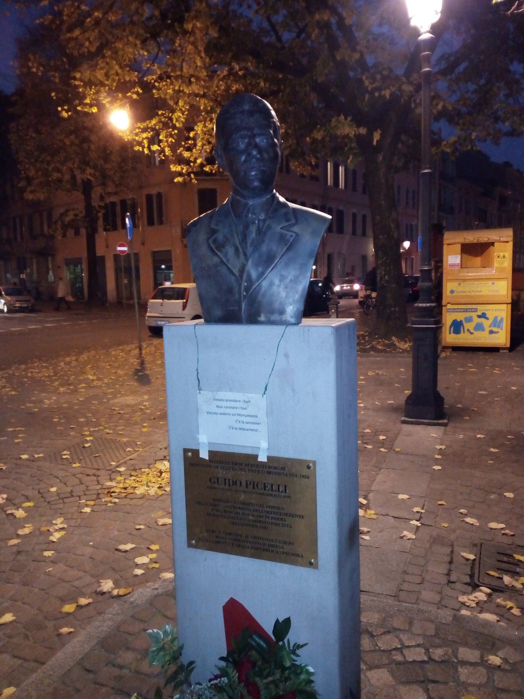 Monumento commemorativo a Picelli, con busto bronzeo su base informativa, situato in un'area urbana.