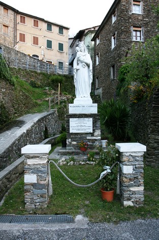 Lapide commemorativa con statua, simbolo di salvezza e resistenza in un contesto storico e culturale.