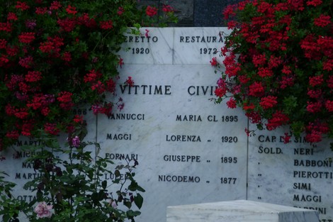 Monumento ai caduti di Levigliani, commemorazione con fiori e nomi iscritti su marmo.