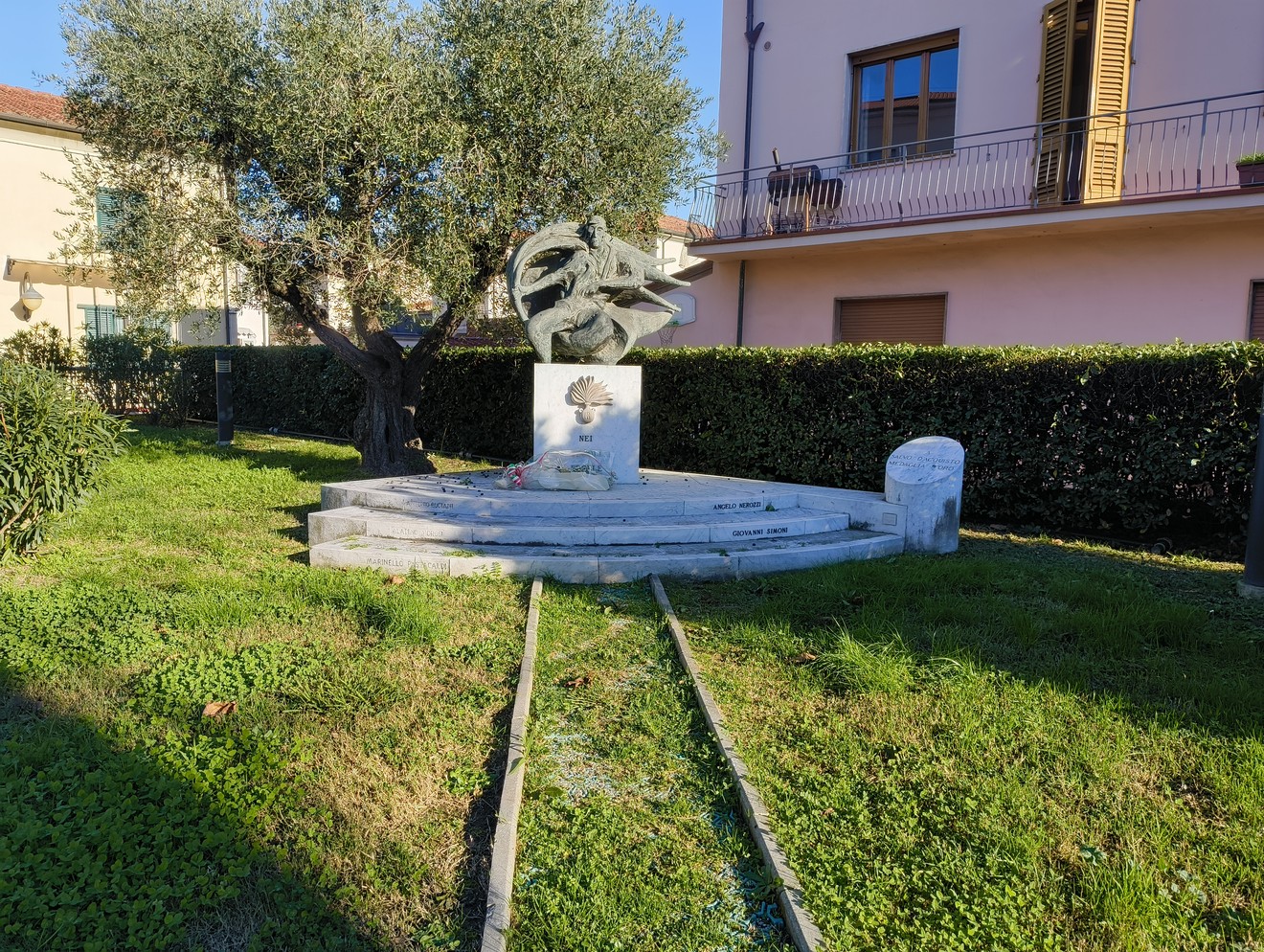 Monumento commemorativo dedicato ai carabinieri caduti, immerso in un verdeggiante giardino.