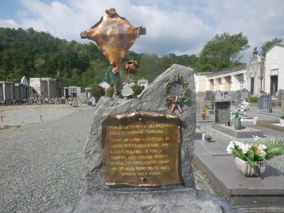 Monumento commemorativo al Sepolcro di Nerva, situato in un cimitero, con dettagli bronzei e iscrizione dedicata.