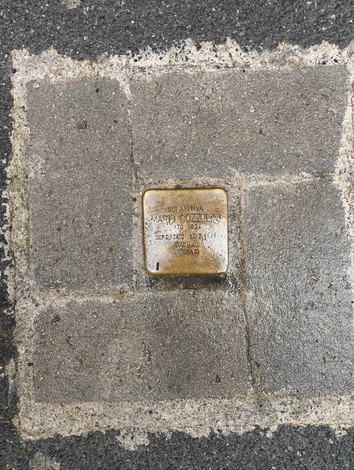 Pietra d'inciampo in memoria di Mario Cozzolini, installata su un marciapiede.