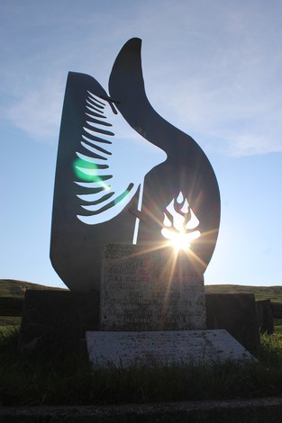 Monumento all'aviolancio di Cadorna, con silhouette stilizzata in metallo contro il sole al tramonto.