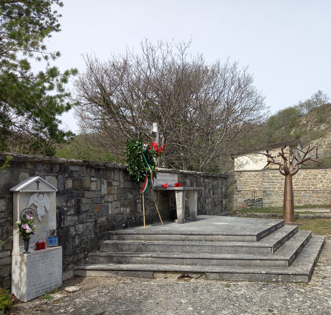 Cenotafio in memoria delle vittime di Fragheto, circondato da una vegetazione e un paesaggio sereno.