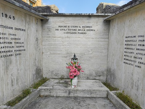 Monumento commemorativo ai caduti della guerra a Corticella, con un omaggio floreale.