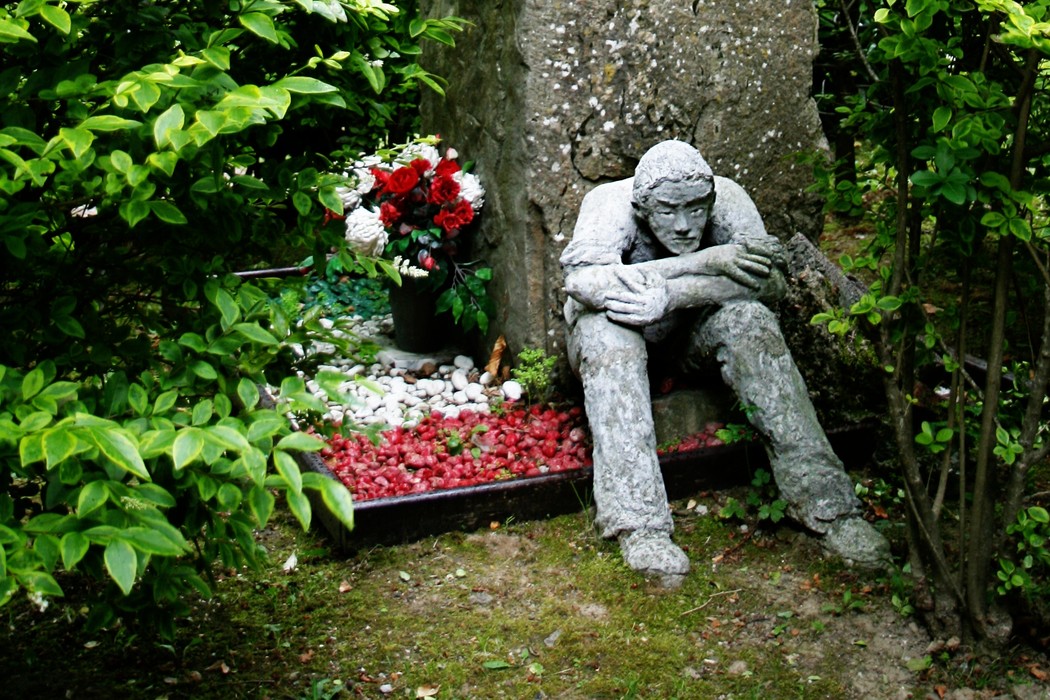 Monumento ai caduti del bombardamento, scultura che rappresenta la sofferenza e la memoria in un giardino commemorativo.