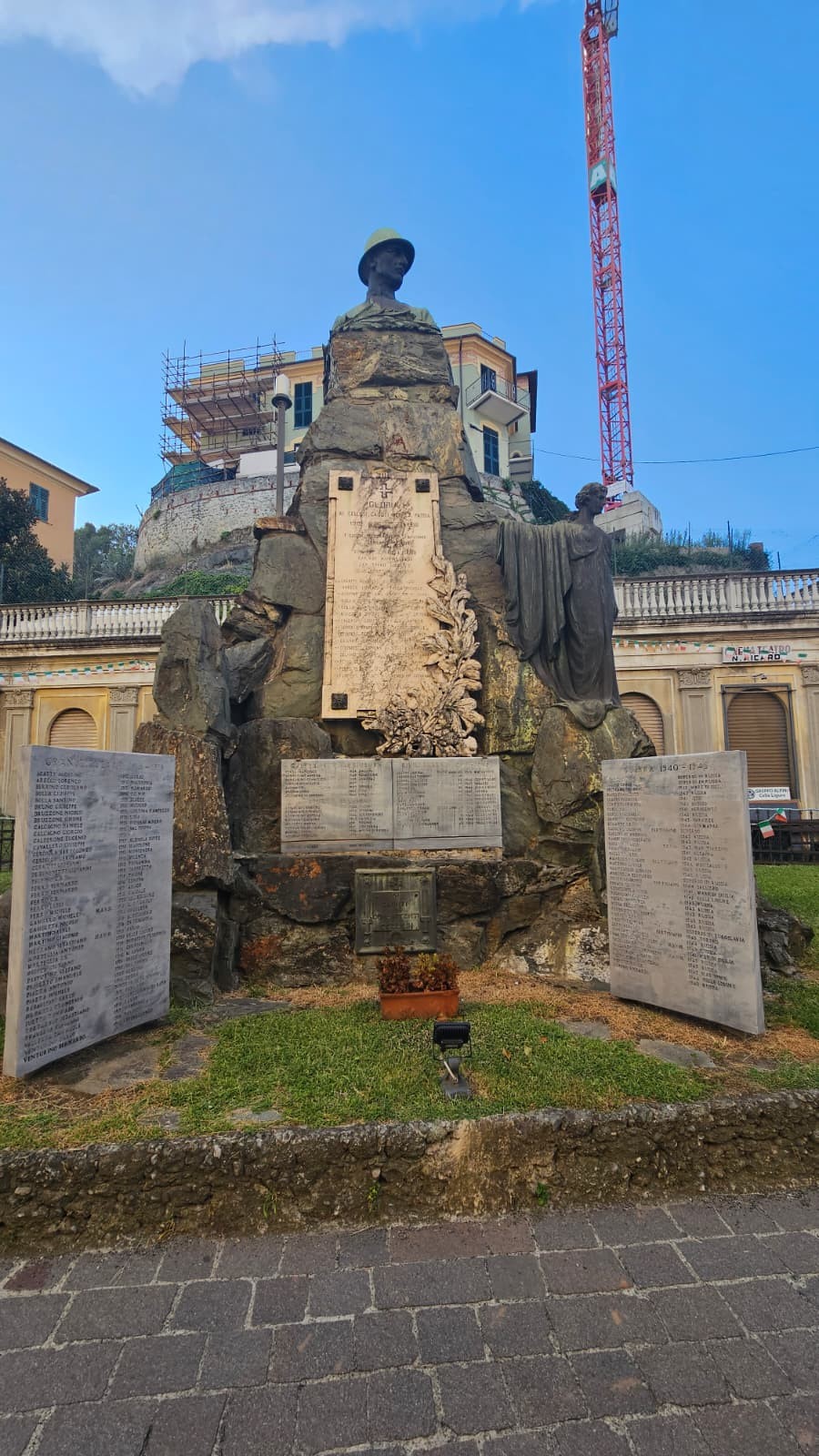 Monumento ai caduti, con statue e placche commemorative, circondato da elementi architettonici storici.