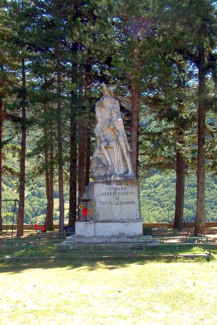 Monumento ai caduti immerso nel verde, onora i sacrifici delle guerre passate con un imponente statua.