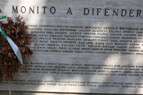 Monumento ai Caduti con iscrizioni commemorative e una corona di fiori in memoria dei caduti.