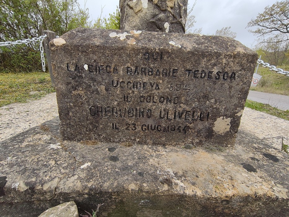 Cippo commemorativo in pietra con iscrizione storica, situato nel verde, vicino a Ulivelli.
