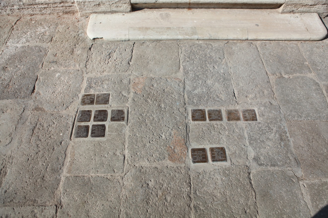 Pietre d'inciampo commemorative disposte su un pavimento in pietra, in memoria degli ospiti della Casa Israelitica di riposo.