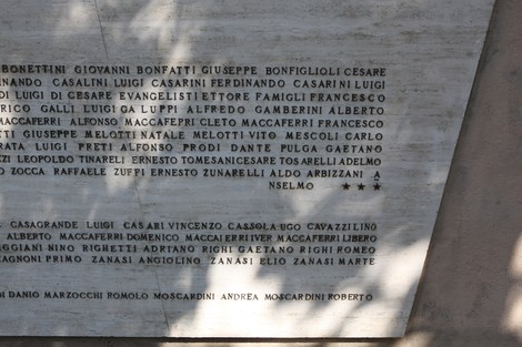 Monumento ai Caduti, commemorazione di eroi con nomi incisi su pietra in un contesto solenne e rispettoso.