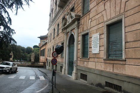 Lapide in onore della Resistenza, situata su un edificio storico in un contesto urbano.