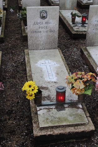 Tomba con epitaffio e fiori, dedicata ai caduti per la libertà, in un cimitero.