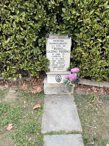Lapide in memoria di Gazino Pierino con fiori e dediche, commemorando la sua vita e il sacrificio per l'Italia.
