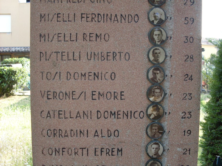 Monumento ai martiri di Sesso, onore ai caduti con nomi e volti incisi in memoria.