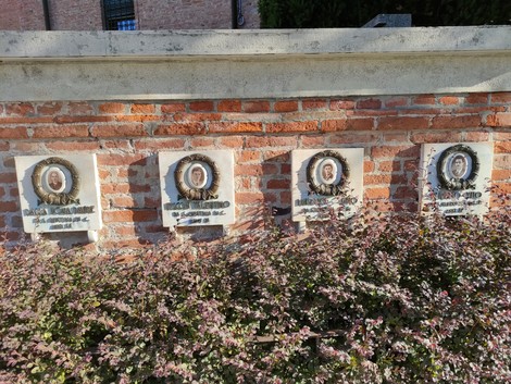 Monumento commemorativo per le vittime dell'eccidio di Santa Giustina in Colle, incastonato in un muro di mattoni.