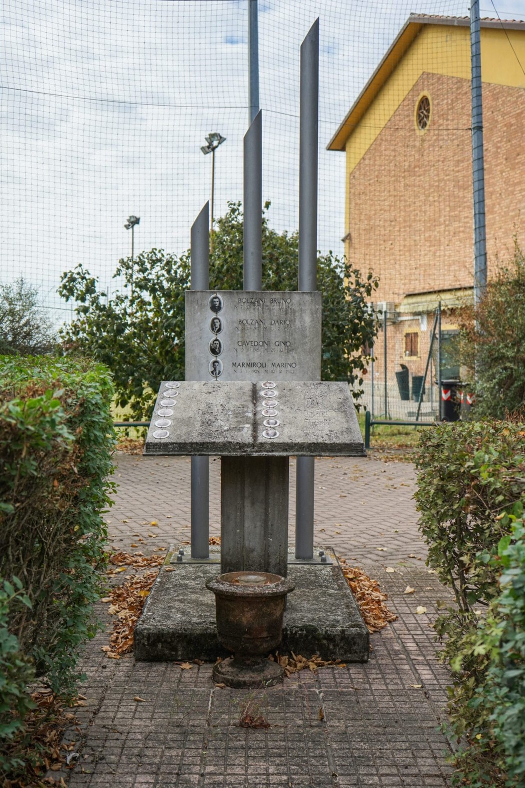 Monumento ai caduti per la libertà di Sozzigalli, in un'area verde con siepi ben curate.