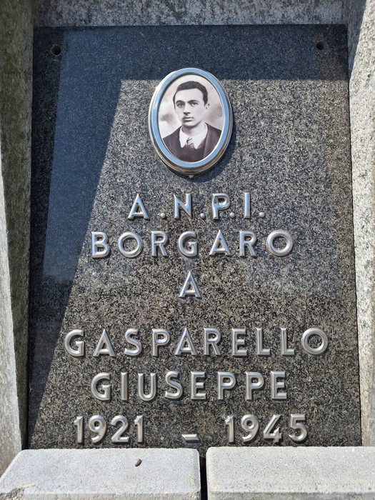 Cippo commemorativo in marmo dedicato a Giuseppe Gasparello con foto in ceramica e iscrizioni.