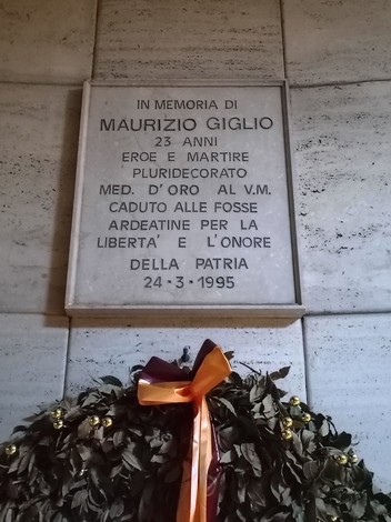 Lapide commemorativa dedicata a Maurizio Giglio, eroe e martire, con una corona di alloro.