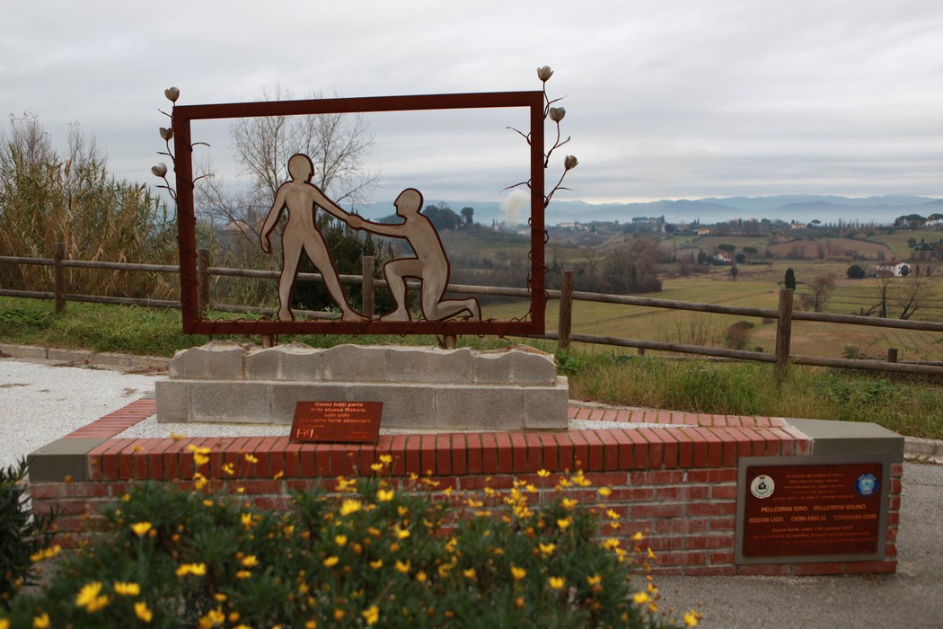 Scultura commemorativa dedicata ai prigionieri dei lager, immersa in un paesaggio evocativo.