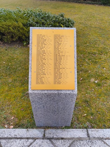 Cimitero militare italiano di Zehlendorf con una stele commemorativa e un'area verde circostante.