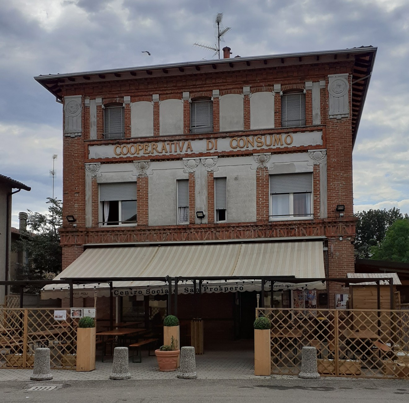 Cooperativa di consumo con lapide commemorativa a Masrati, Casadio e Bolognesi. Edificio storico in mattoni.