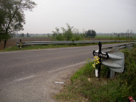 Croce a Collarini su strada, circondata da verde e campi, simbolo di memoria e rispetto.