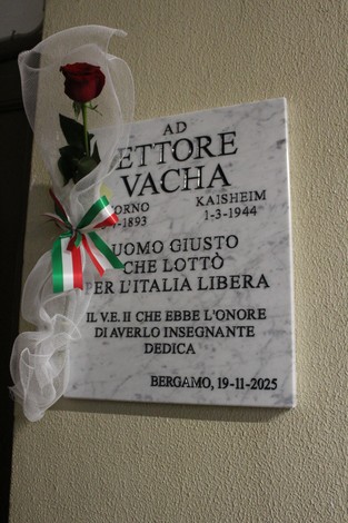 Lapide commemorativa dedicata a Ettore Vachà, con una rosa e un nastro tricolore.
