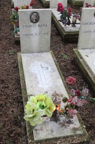 Tombe nel cimitero dedicate ai caduti per la Libertà, con fiori e lumini commemorativi.