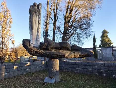 Monumento ai caduti della Liberazione, scultura su base rocciosa, immerso in un paesaggio autunnale.