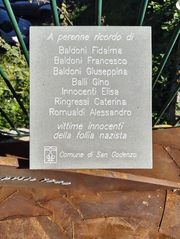 Monumento commemorativo dedicato alle vittime della strage di Castagno, con nomi incisi su una placca.