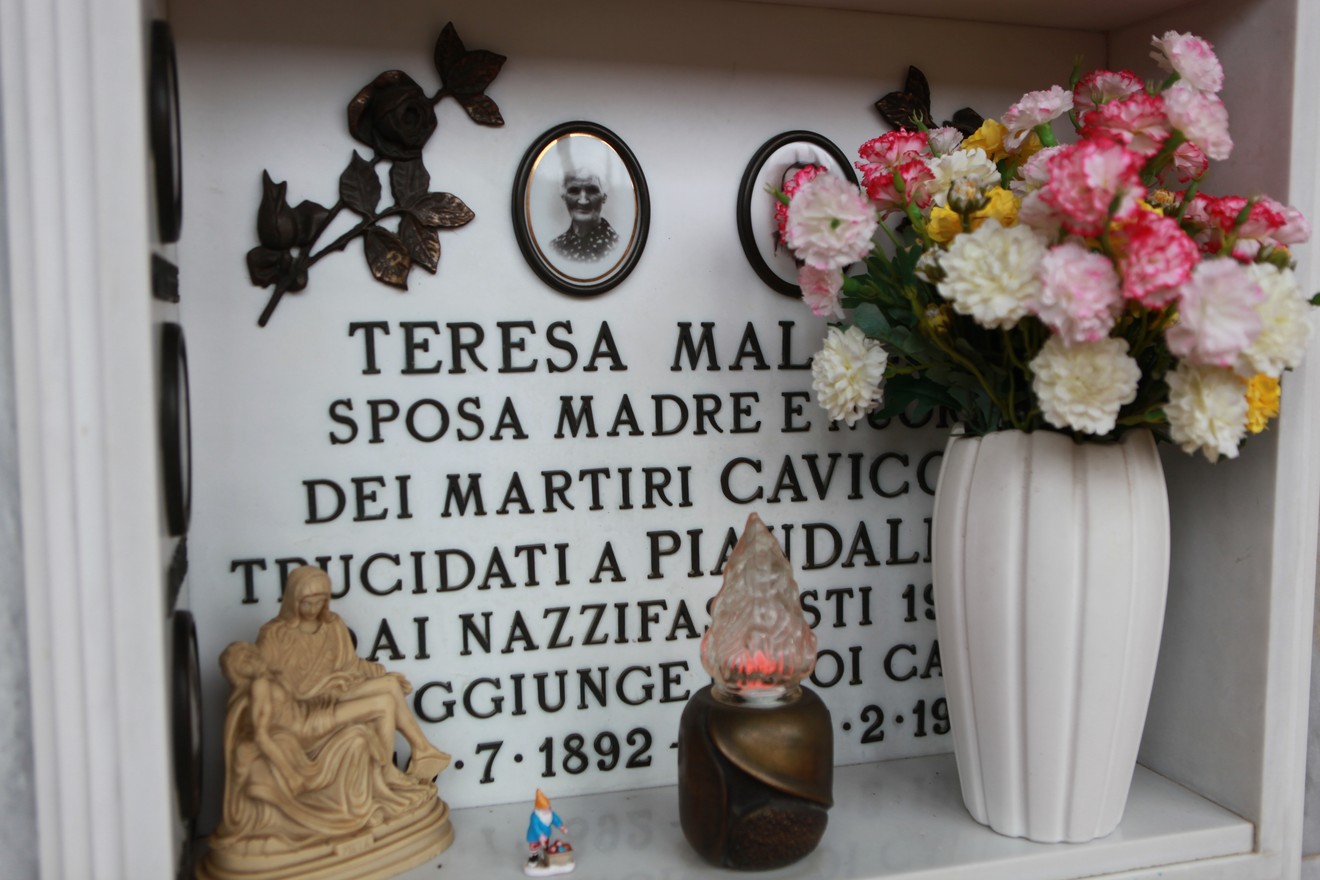 Sepolcro della famiglia Cavicchi, con decorazioni floreali e oggetti commemorativi.