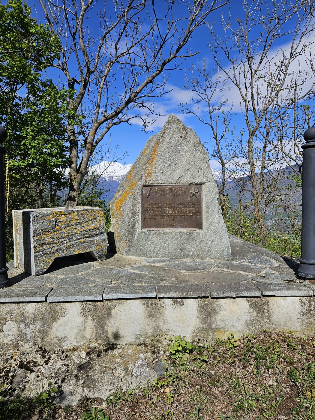 Monumento in memoria degli alpini e partigiani, situato tra Inverso e Mattie, circondato da natura.