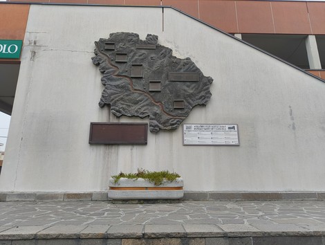 Monumento ai partigiani caduti di Pianoro, rappresentato da una scultura in rilievo su un muro.