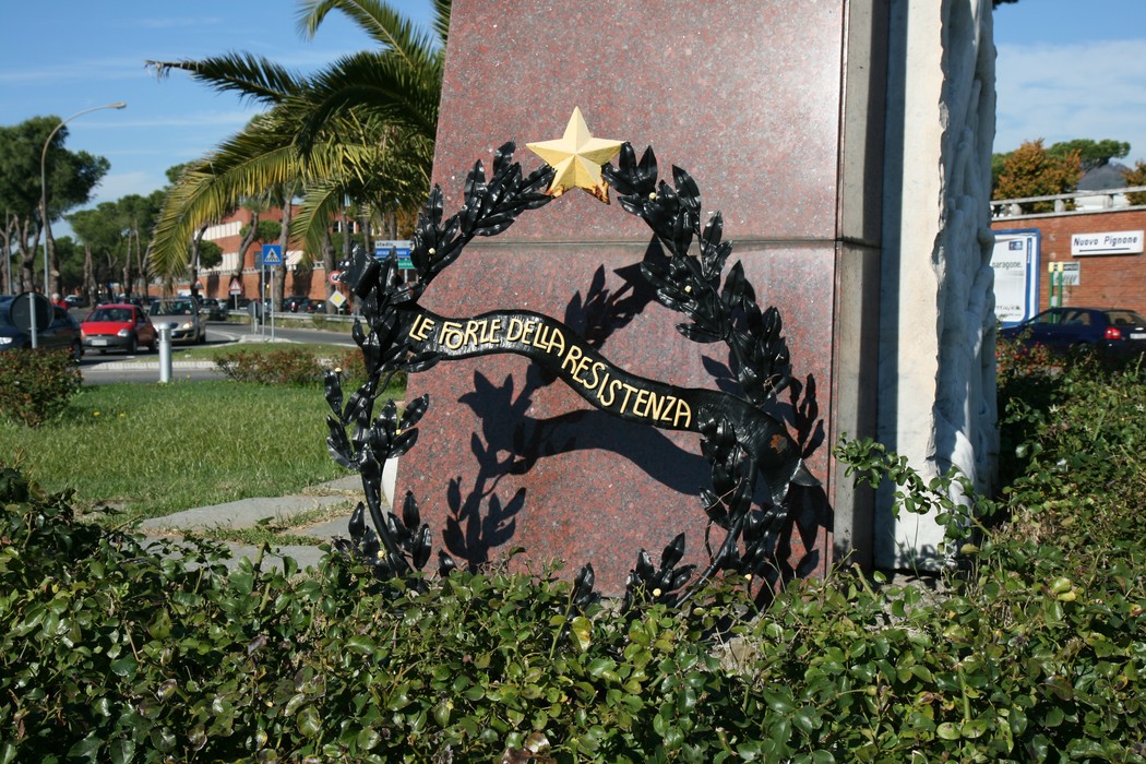 Monumento commemorativo alle vittime delle stragi di Apuania, con una corona di alloro e una stella.