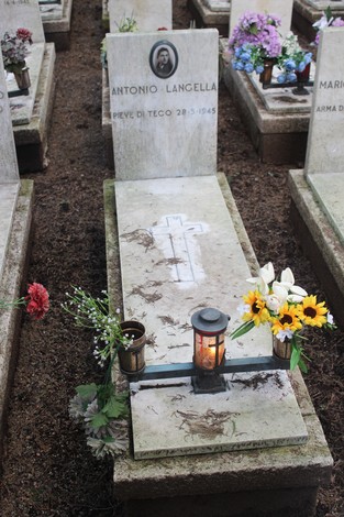Tombe perpetue decorate con fiori, in memoria dei caduti per la Libertà. Atmosfera di rispetto e commemorazione.
